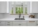 Kitchen sink with white stone countertops, matching backsplash, and view of outdoor greenery at 4785 Longchamps Dr, Sandy Springs, GA 30319