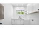 Well-lit laundry room with white cabinets, quartz countertops, and a modern sink, making chores easy at 4785 Longchamps Dr, Sandy Springs, GA 30319