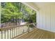 Relaxing porch area with wooden floor, black iron railing, and green tree surroundings at 4785 Longchamps Dr, Sandy Springs, GA 30319