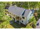 Aerial view of the back of a two-story modern farmhouse with a deck and landscaped yard at 4785 Longchamps Dr, Sandy Springs, GA 30319