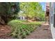 View of backyard showing trees and small green plantings, with rear of building in background at 4912 Waters Edge Trl, Roswell, GA 30075