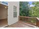 Balcony with wood floor and railing overlooking lush, green trees at 4912 Waters Edge Trl, Roswell, GA 30075