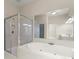 Bright bathroom featuring a soaking tub, glass enclosed shower, and large mirrors at 4912 Waters Edge Trl, Roswell, GA 30075