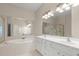 Bright bathroom featuring a double sink vanity, soaking tub, and large mirrors at 4912 Waters Edge Trl, Roswell, GA 30075