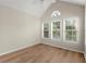 Large bedroom with vaulted ceilings, hardwood floors, and three windows with blinds at 4912 Waters Edge Trl, Roswell, GA 30075