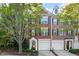 Charming three-story brick townhome with attached garages, mature landscaping, and welcoming entrance at 4912 Waters Edge Trl, Roswell, GA 30075