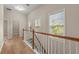 Hallway with hardwood floors and natural light from windows by the stairway at 4912 Waters Edge Trl, Roswell, GA 30075