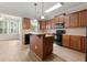 Well-equipped kitchen with wood cabinets, stainless steel appliances, and a central island with pendant lighting at 4912 Waters Edge Trl, Roswell, GA 30075