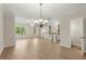 Bright and open living area featuring wood floors, a chandelier, staircase, and large windows at 4912 Waters Edge Trl, Roswell, GA 30075