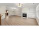 Open-concept living room with wood floors, a fireplace, built-in shelves, and ample natural light at 4912 Waters Edge Trl, Roswell, GA 30075