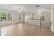 Bright living room with wood floors, ceiling fan, large windows, and staircase access at 4912 Waters Edge Trl, Roswell, GA 30075
