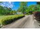 Long concrete driveway with lush landscaping leading to a charming home creating a serene approach at 1170 Moseley Rd, Stockbridge, GA 30281