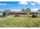 View of the brick house exterior and well maintained backyard with green grass, shrubbery, and trash cans at 4861 Alcan Rd, Powder Springs, GA 30127