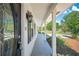 Close-up of front porch featuring black door, lighting, and supporting pillars, enhanced by landscaping at 4861 Alcan Rd, Powder Springs, GA 30127