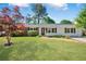 Charming home featuring a well-manicured front yard, a brick walkway, and a welcoming porch and black shutters at 4861 Alcan Rd, Powder Springs, GA 30127