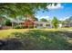 Lovely single-Gathering home with a verdant lawn, mature trees, and a brick accent wall near the entrance at 4861 Alcan Rd, Powder Springs, GA 30127