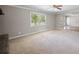 Open living room with large windows, ceiling fan, and view to the front entryway at 4861 Alcan Rd, Powder Springs, GA 30127