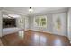 Hardwood floors and neutral paint enhance living room, seamlessly connected to a cozy den with a fireplace at 4861 Alcan Rd, Powder Springs, GA 30127