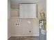 Utility room with water heater, overhead storage, and a hookup for laundry equipment in neutral colors at 4861 Alcan Rd, Powder Springs, GA 30127
