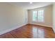 Simple bedroom with hardwood floors, neutral paint, and a bright window at 5201 Skyline Dr, Stone Mountain, GA 30083