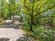 View of property and driveway, including address sign, lawn, trees, and home in the background at 5201 Skyline Dr, Stone Mountain, GA 30083