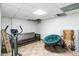 Uncluttered basement area featuring a futon, artwork, and exercise equipment, offering potential for customization at 5272 Cumberland Way, Stone Mountain, GA 30087