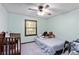 Bright bedroom with a crib, a bed, a ceiling fan, a window, and an accent wall at 5272 Cumberland Way, Stone Mountain, GA 30087