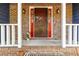 Inviting brick entryway with a red-trimmed brown front door, enhanced by sidelights and sconces at 5272 Cumberland Way, Stone Mountain, GA 30087