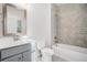 Bathroom with a gray vanity, toilet, mirror, and a bathtub with tiled walls at 811 Corsiglia Farm, Marietta, GA 30060