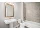 Bathroom featuring a pedestal sink, toilet, mirror, and a bathtub with tiled walls at 811 Corsiglia Farm, Marietta, GA 30060