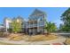 Inviting two-story home with a charming front porch, set against a backdrop of lush trees and a clear blue sky at 811 Corsiglia Farm, Marietta, GA 30060