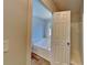 Ensuite bathroom featuring a soaking tub, tile walls and wood-look flooring at 145 Charleston Pl, Covington, GA 30016