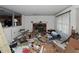 Untidy living room featuring a fireplace, window, and partial view into the kitchen, showing signs of needed repair at 3090 Sunset Se Rd, Conyers, GA 30094