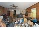 Cluttered living room with wood paneling, a vintage ceiling fan, and a window offering natural light at 3090 Sunset Se Rd, Conyers, GA 30094