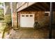 Stone facade features a one car garage and steps up to the house, with electric vehicle charger at 400 Collier Rd, Atlanta, GA 30309