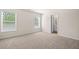 Carpeted bedroom featuring two windows and ensuite bathroom at 5443 Blossomwood Sw Trl, Mableton, GA 30126