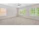 Spacious bedroom with two large windows that bring in ample natural light and neutral colored carpeting at 5443 Blossomwood Sw Trl, Mableton, GA 30126