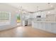 Open-concept kitchen with white cabinets, island, stainless appliances, and access to an outdoor deck at 5443 Blossomwood Sw Trl, Mableton, GA 30126