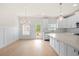 Bright kitchen and dining area featuring white cabinetry, light wood floors, and contemporary lighting at 5443 Blossomwood Sw Trl, Mableton, GA 30126