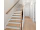 Beautiful stairway with wooden steps, white risers, and modern wood flooring leading to the upper level at 5443 Blossomwood Sw Trl, Mableton, GA 30126