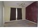 Bedroom featuring a ceiling fan, window with curtains, two-tone walls, and neutral carpet at 7238 April Ct, Morrow, GA 30260