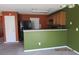 A kitchen featuring wood cabinets, a black refrigerator, and a green wall at 7238 April Ct, Morrow, GA 30260