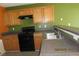Kitchen featuring wood cabinets and black appliances at 7238 April Ct, Morrow, GA 30260