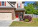 Inviting home entrance with a red front door, stone accents, and a well-manicured lawn at 100 Cottage Nw Walk, Cartersville, GA 30121