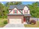 Charming two-story home with a stone accent garage, red shutters, and a landscaped front yard at 100 Cottage Nw Walk, Cartersville, GA 30121