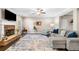 Open living room with a stone fireplace, ceiling fan, hardwood floors, and a comfortable sectional sofa at 100 Cottage Nw Walk, Cartersville, GA 30121