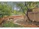 Picturesque backyard with a brick pathway, a wooden fence, and mature trees at 4272 Glenlake Nw Dr, Kennesaw, GA 30144