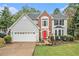 Charming two-story home with a red front door, gray siding, brick accent, a manicured lawn, and a two-car garage at 4272 Glenlake Nw Dr, Kennesaw, GA 30144