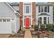 Close-up of a well-maintained home with a bright red door, gray siding, brick accent, and professional landscaping at 4272 Glenlake Nw Dr, Kennesaw, GA 30144
