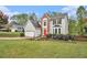 Charming two-story home with a red front door, gray siding, brick accent, a manicured lawn, and a two-car garage at 4272 Glenlake Nw Dr, Kennesaw, GA 30144
